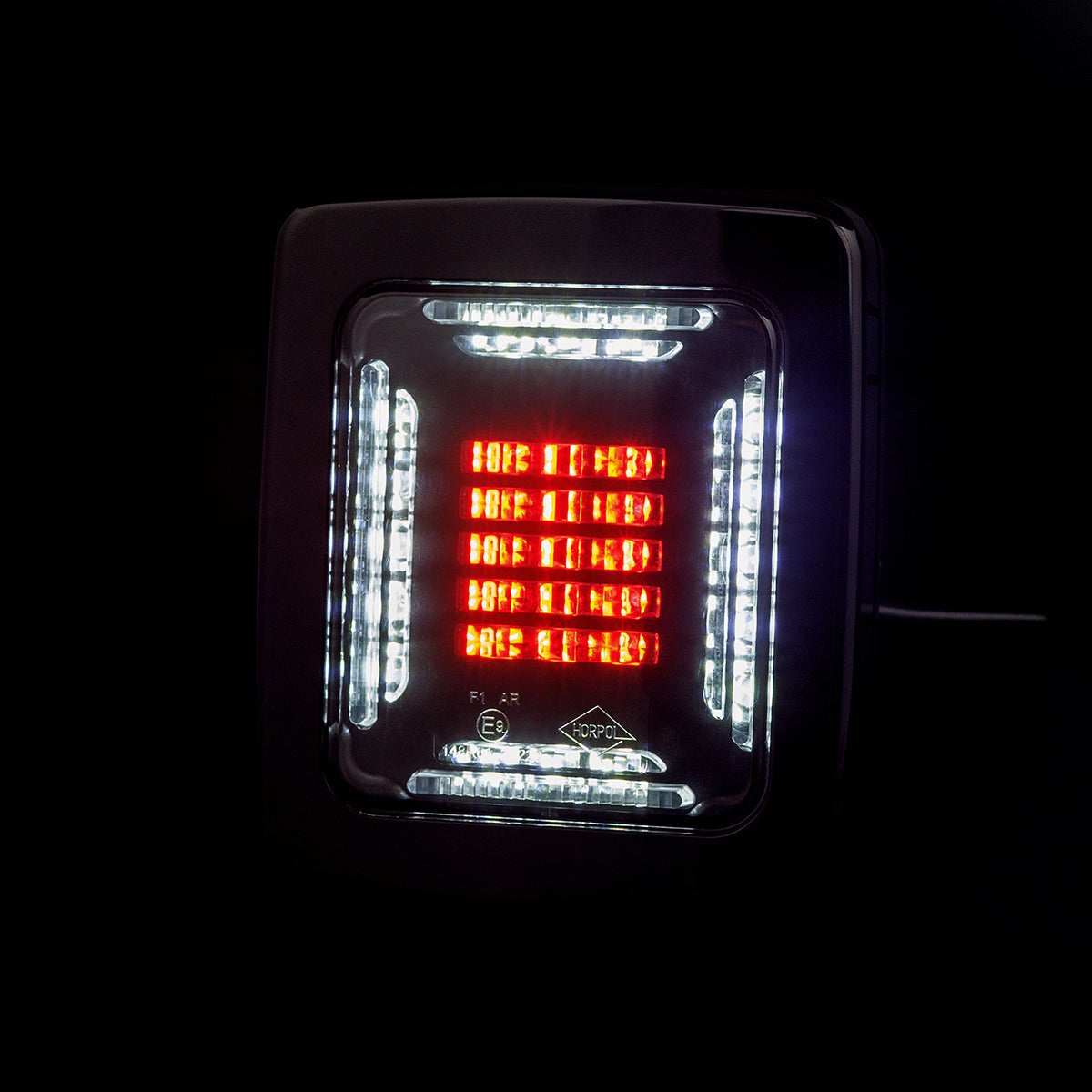 LED tail light with red and white lights on a black background