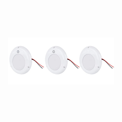Three white LED puck lights with wires on a white background